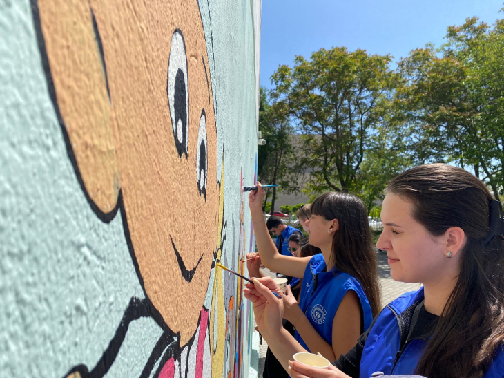Gönüllü gençler okul bahçesini renklendirmek için çalışıyor