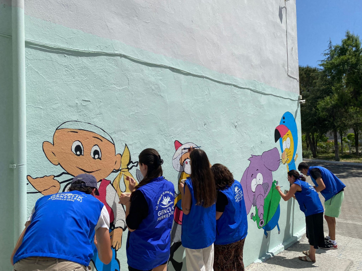 Gönüllü gençler okul bahçesini renklendirmek için çalışıyor